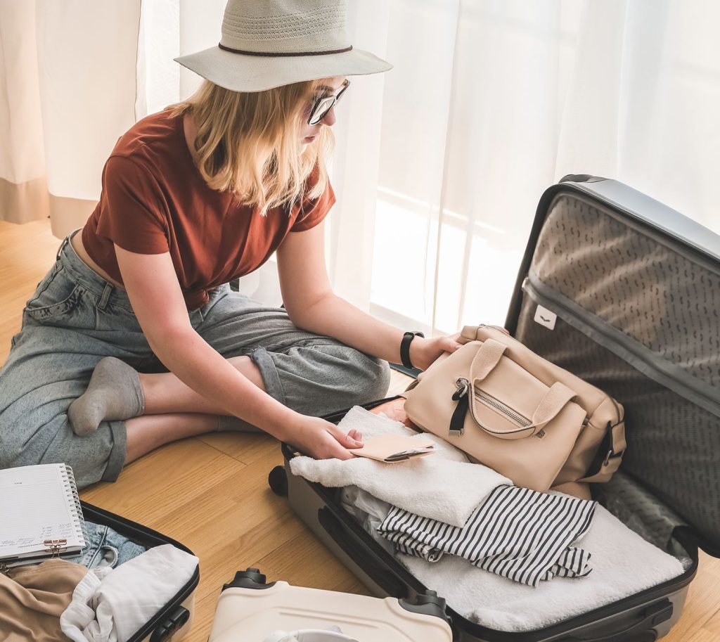 Female packing bags and organizing passport 