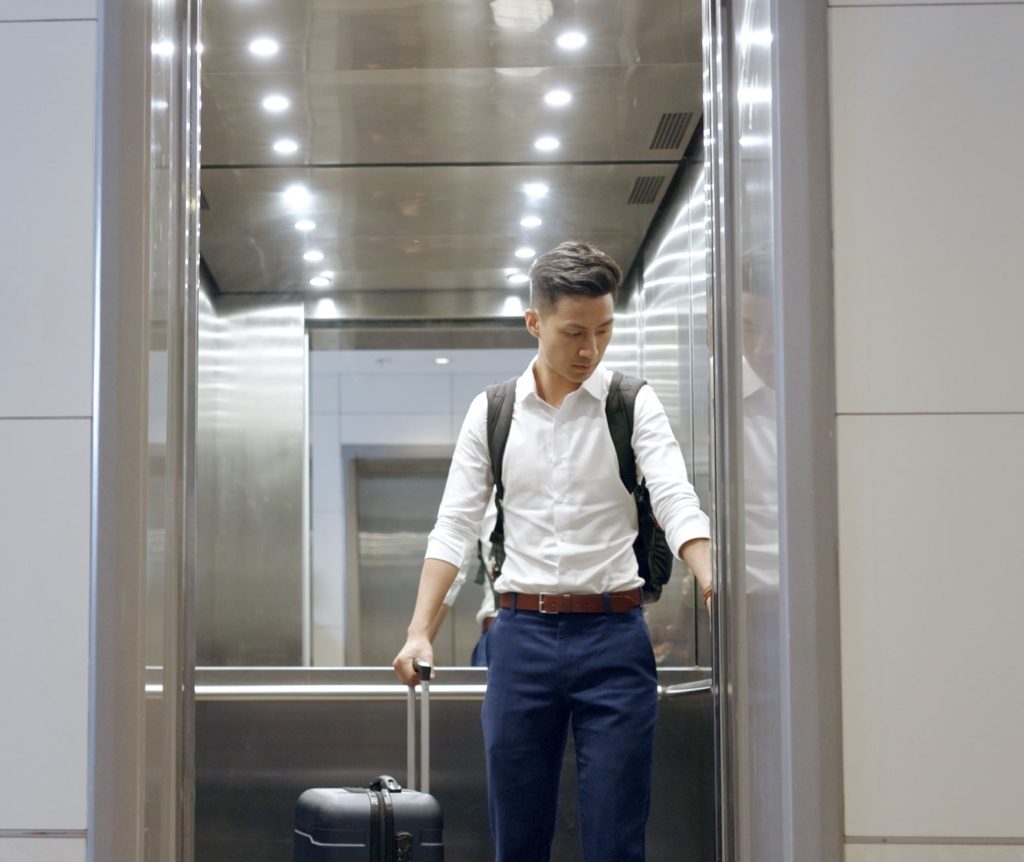 Man Taking Elevator with luggage