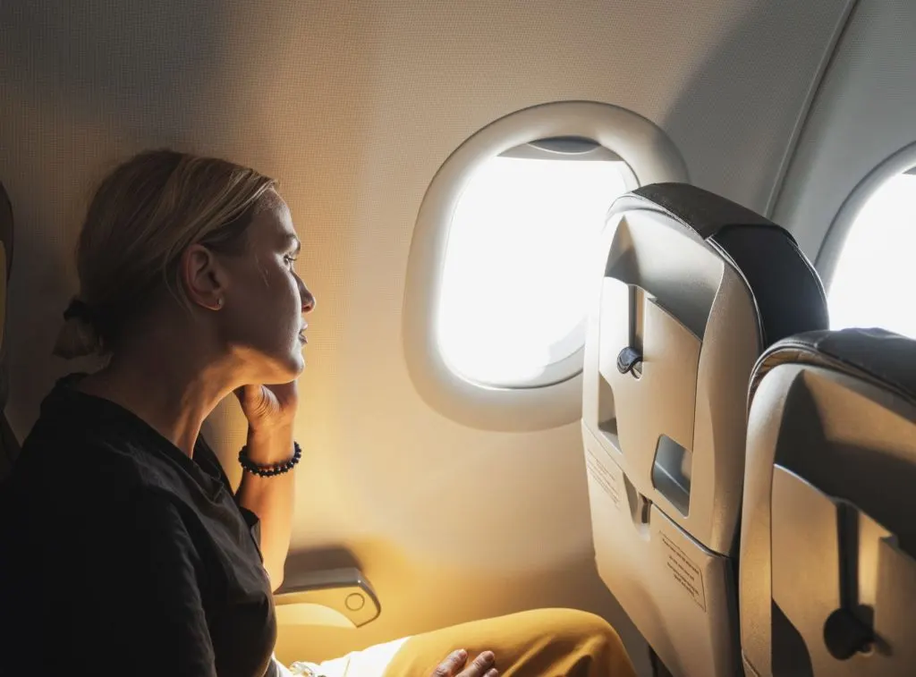 Woman on plane thinking about trip 